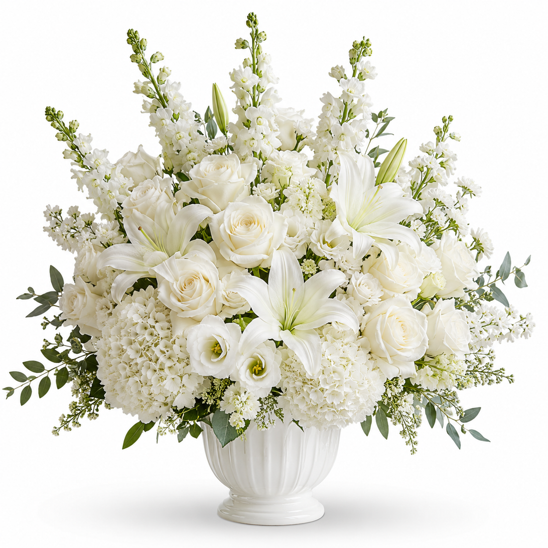 Pure Serenity Arrangement - lush all-white floral arrangement with lilies, roses and hydrangeas in a white ceramic urn vase