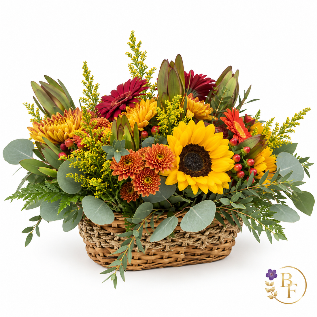 Autumn floral arrangement in woven basket with sunflower, mums and seasonal greenery