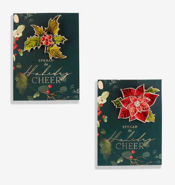 Christmas brooches in poinsettia and holly designs on holiday sentiment cards.