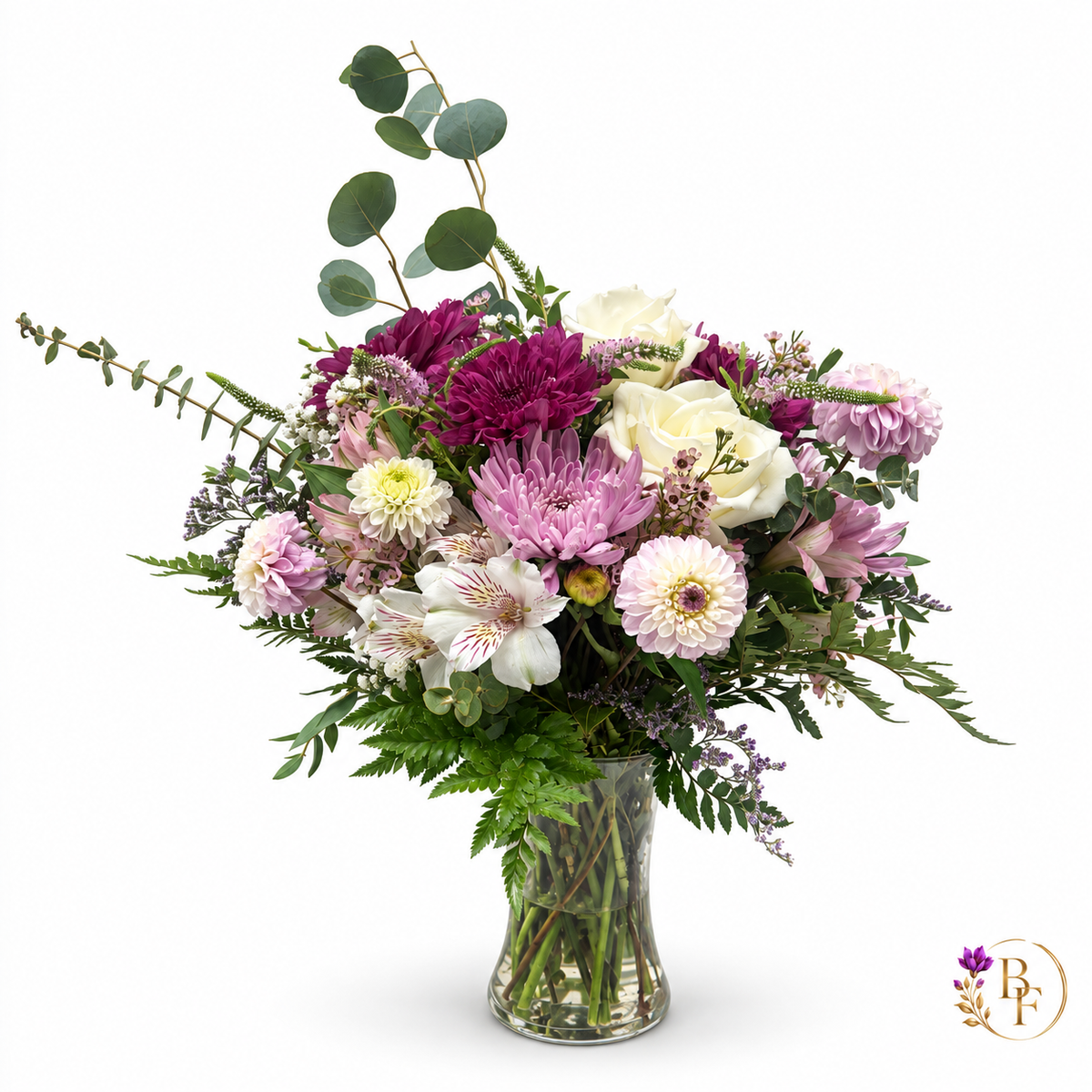 Lavender & Plum arrangement with ivory roses, plum and lavender blooms, alstroemeria and eucalyptus in a clear glass vase