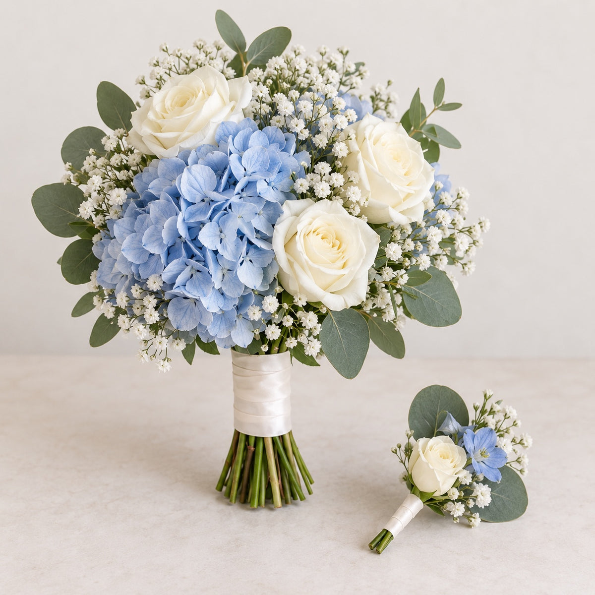 Soft white and blue bridal bouquet with matching boutonniere