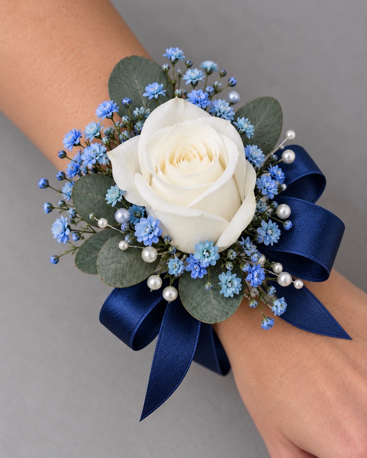 Blue wrist corsage with white rose, blue accents and blue ribbon