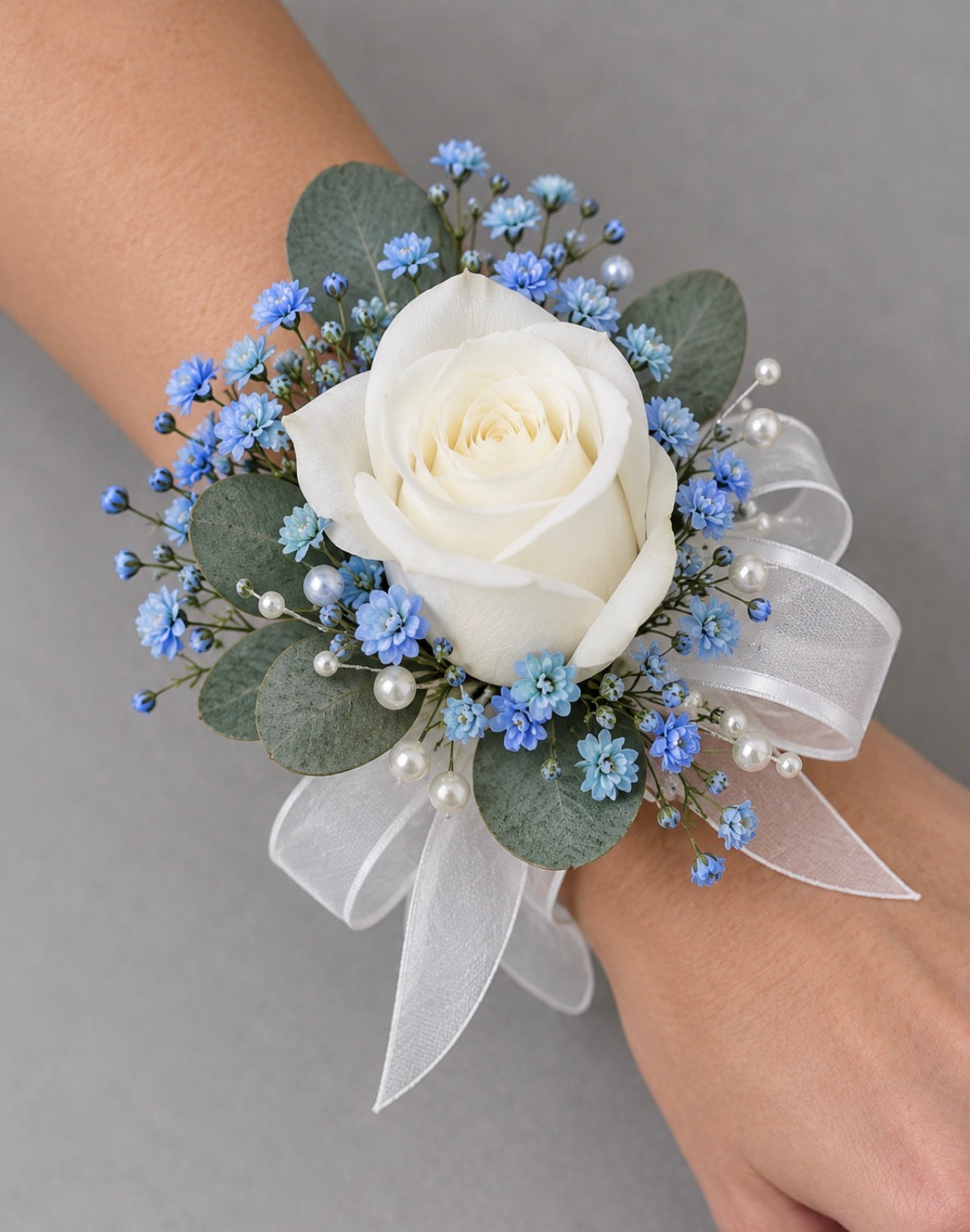 White ribbon wrist corsage with white rose and blue floral accents